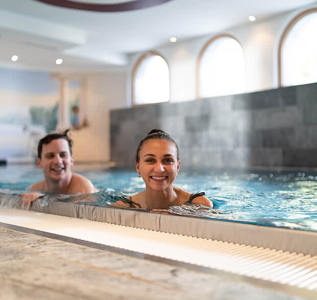 Paar beim Wellnessurlaub im Pool im Hotel Solaria Ischgl