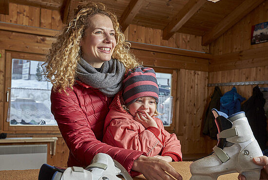 Frau mit Kind und Eislaufschuhen in Ischgl